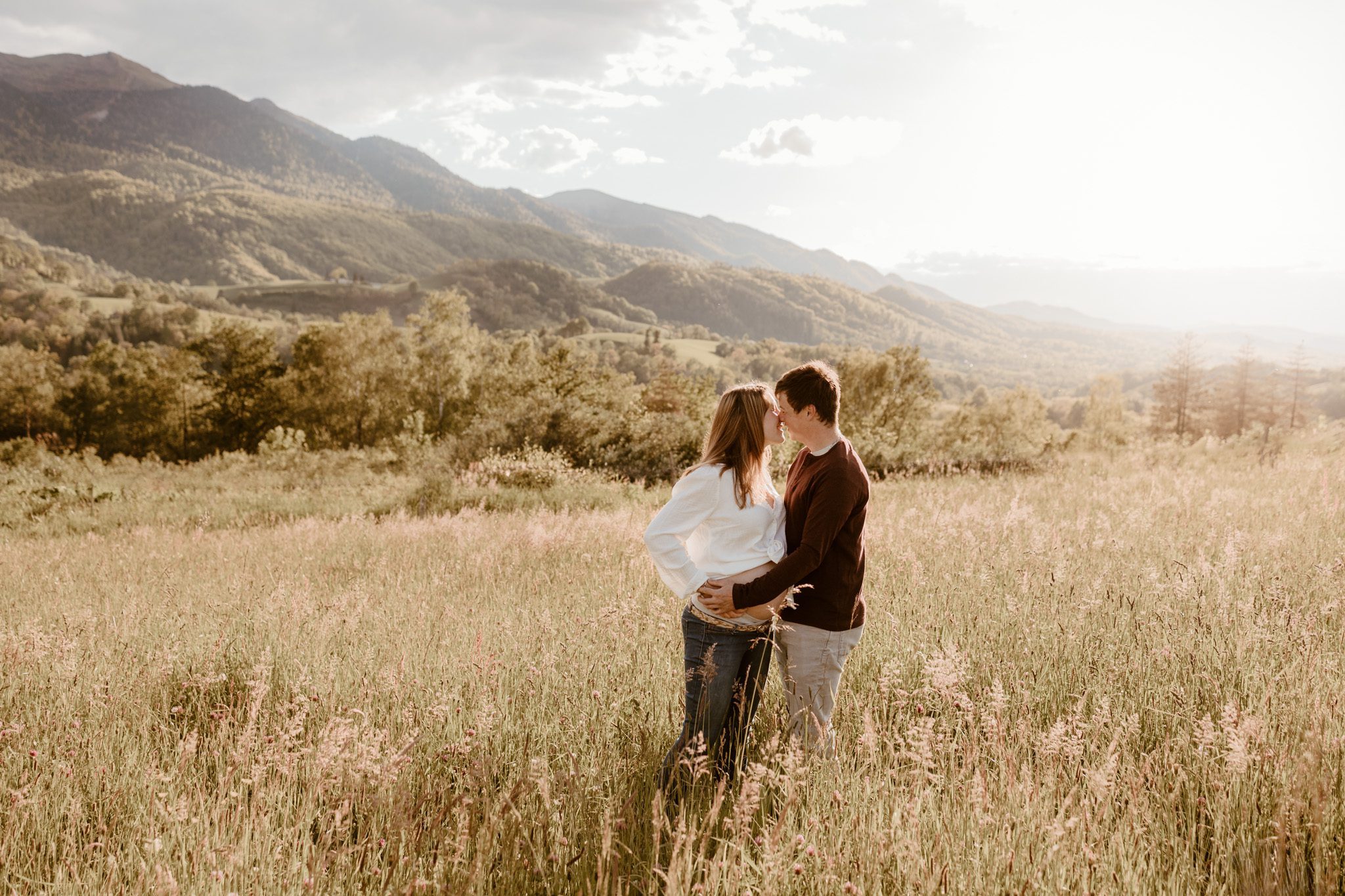 futurs parents dans une prairie ensoleillée au pied des Pyrénées Par Marine Delforge photographe à Pau, Pyrénées-Atlantiques www.marinedelforge.fr